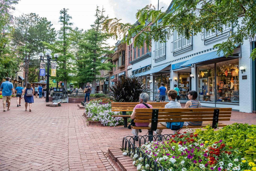Boulder, CO - August 28, 2021: Women friends sit together and enjoy the evening on the famous Pearl Street Mall, downtown, on a beautiful evening.